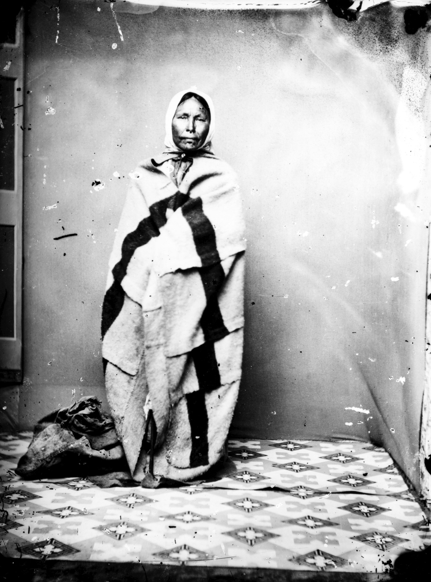 A photograph of a Haida woman standing in front of a wall.