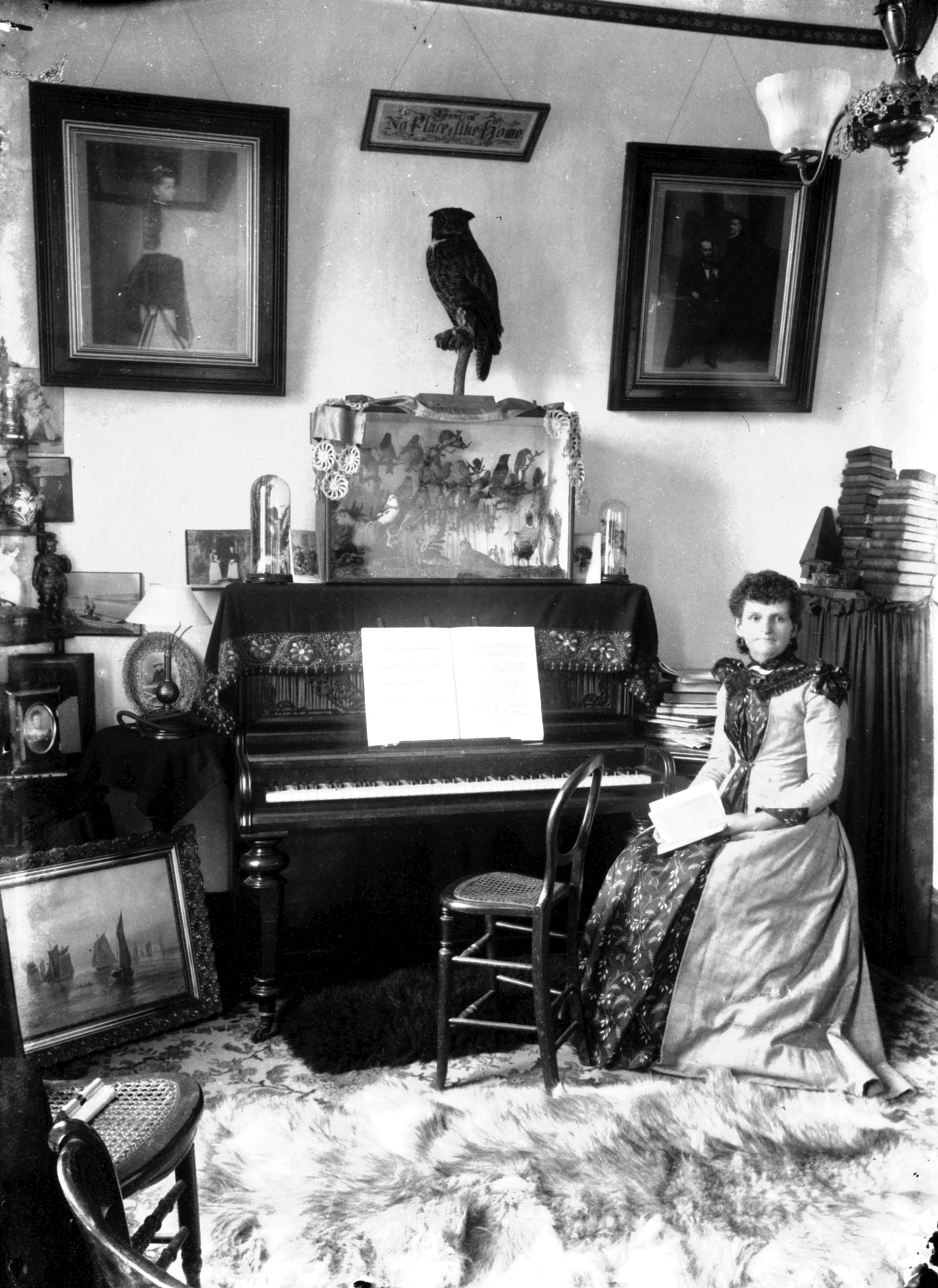 A photograph of Maynard sitting next to a piano.