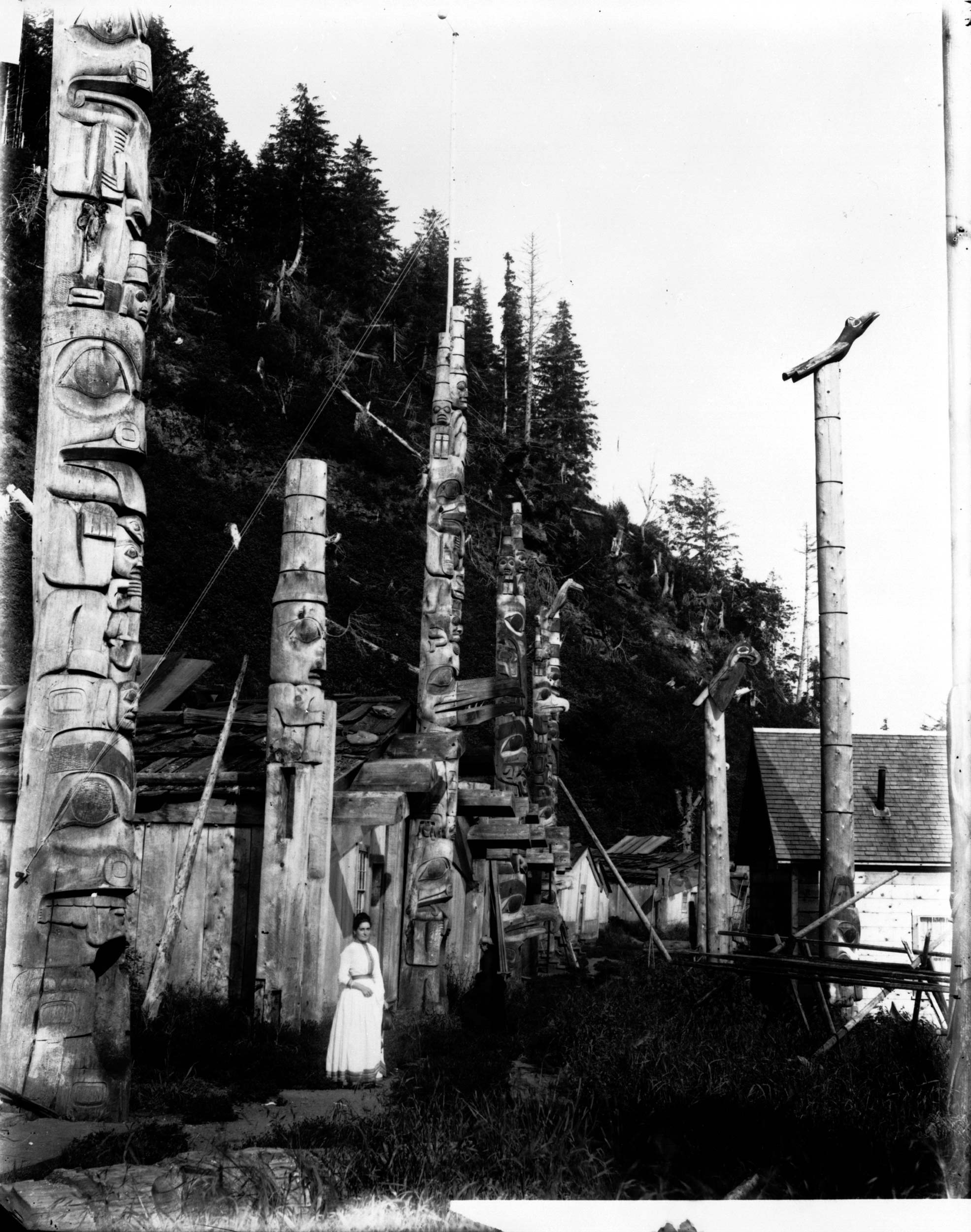 A black and white photograph of totem poles.