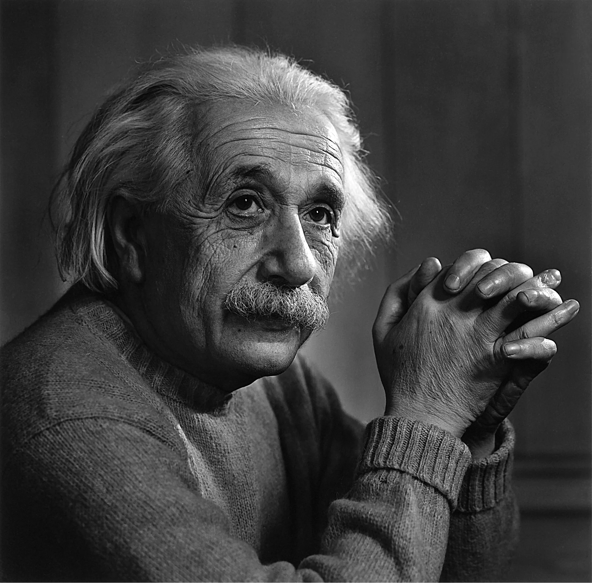 Albert Einstein with his hands folded in front of him.