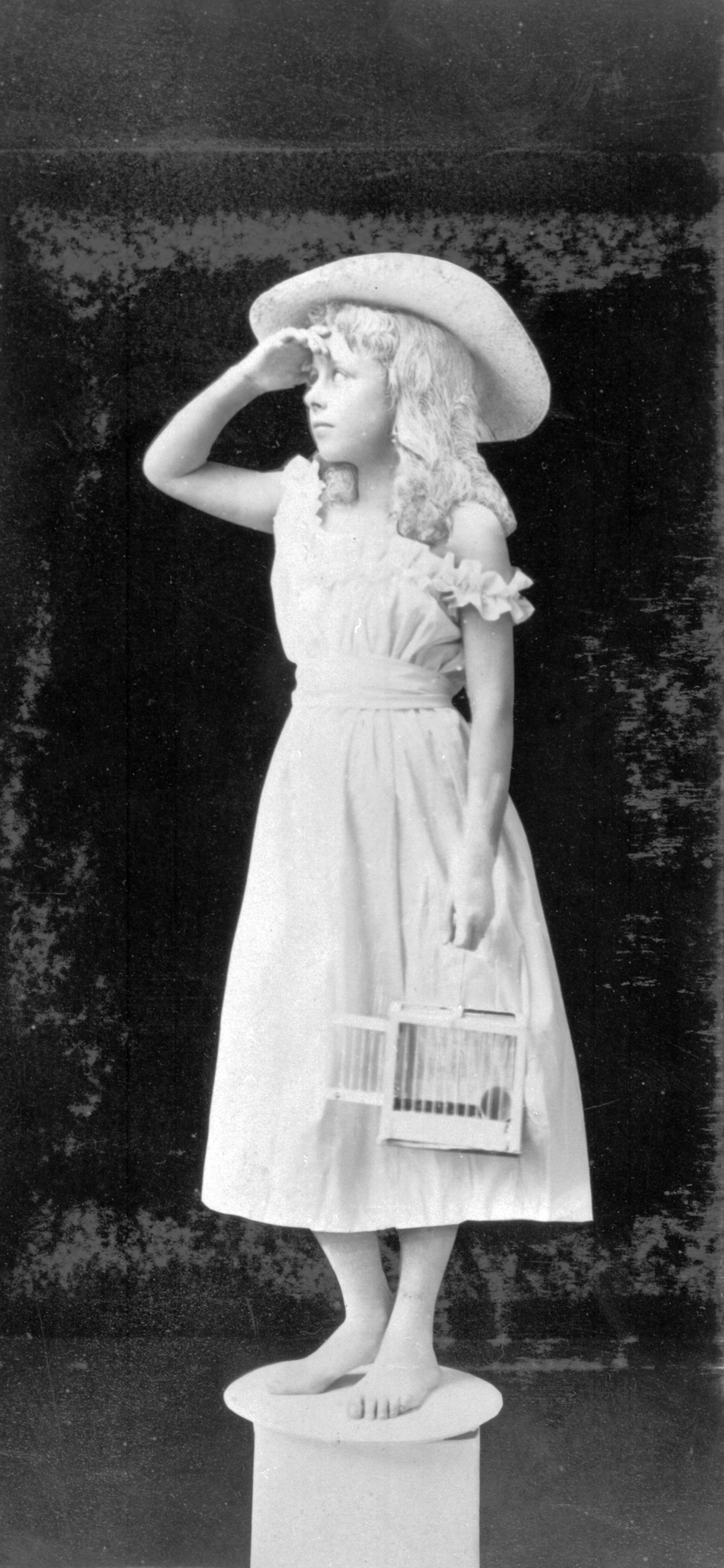 A trick photograph of a young girl as a statue.